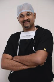 Portrait photo of Dr Gauresh Palekar, middle-aged man with glasses and mustache