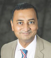 Portrait photo of Dr Pradeep Moonot, middle-aged man with glasses and mustache