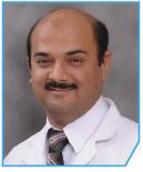 Portrait photo of Dr Chetan Pradhan, middle-aged man with mustache and bald head